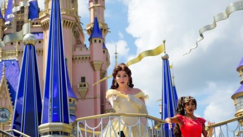 Disney princesses waving from a parade float in front of the Cinderella Castle at Disney World