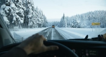 driver view on snowy road during winterizing an RV for cold weather travel