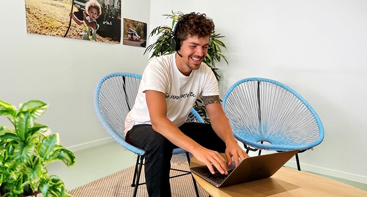 Employee with headset sitting in front of his laptop ready for the next webinar