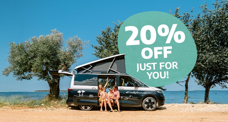 Family of four sitting in the doorway of a campervan