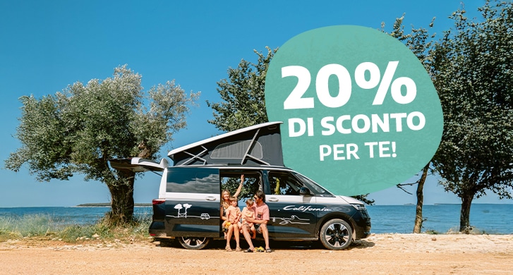 Family of four sitting in the doorway of a campervan