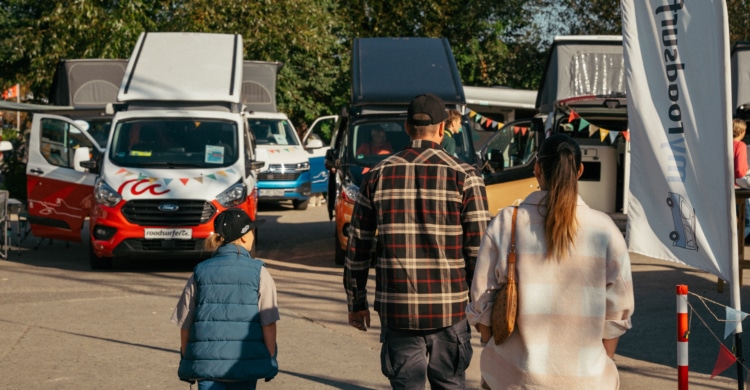 Family walking onto yard with campervans for sale.