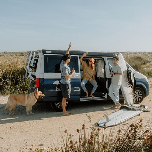 Some friends having fun and talking in a camper standing at the beach