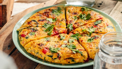 Delicous frittata with potatoes, vegetables and parmesan, view from the side