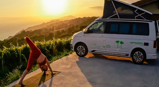 Girl doing yoga in front of a campervan during sunrise