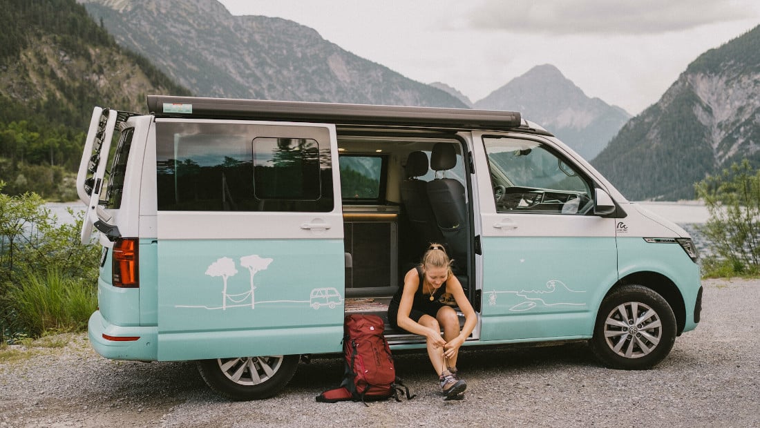 https://roadsurfer.com/wp-content/uploads/girl-in-a-campervan-putting-on-her-shoes-for-a-hike.jpg