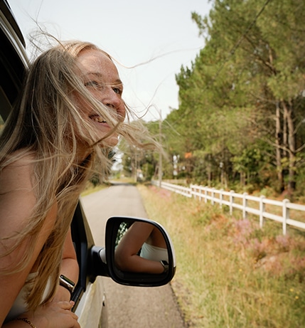 Girl Looking Out Window With Hair Blowing