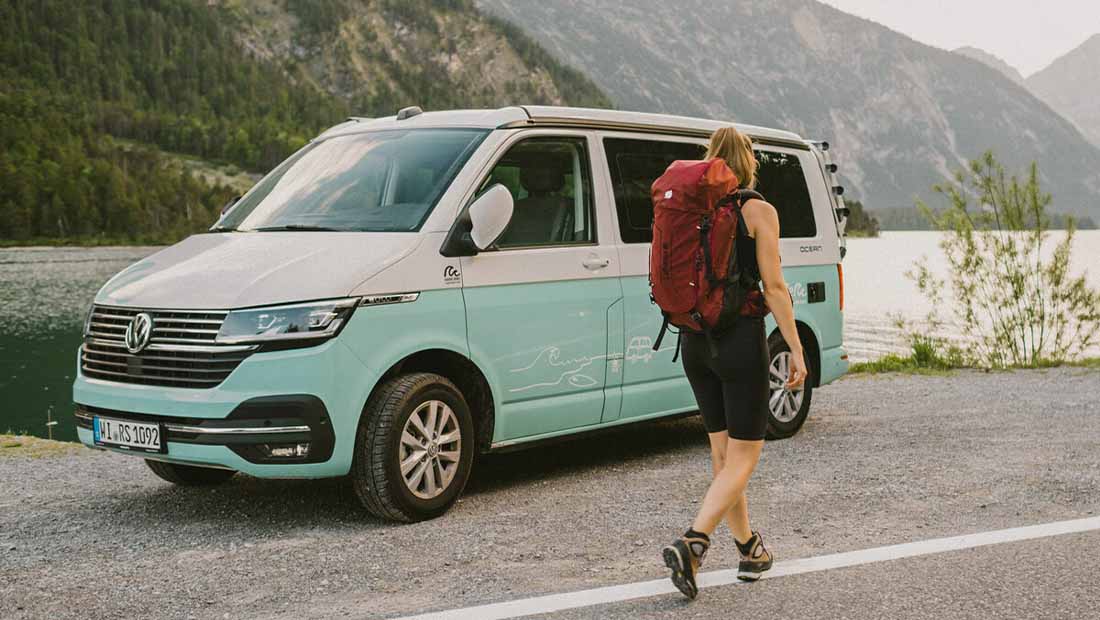 girl with backpack hiking next to a campervan