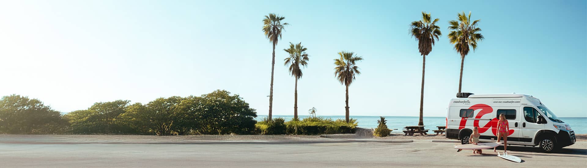 Girls Getting Ready To Surf Outside Camper Van