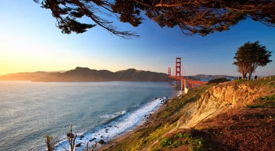Golden Gate Bridge viewed from the coastal cliffs at sunset, a dramatic finale to a Las Vegas to California road trip