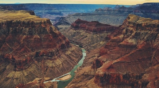 sweeping view of the Grand Canyon and Colorado River at sunset, a highlight of an Arizona road trip itinerary