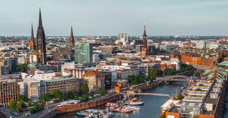 Bird view over the city of Hamburg in Germany. You can clearly see a lot of building and even higher churches, as well as the river flowing through the city.