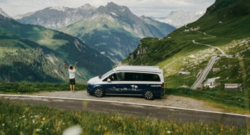 Happy person with campervan and mountain scenery