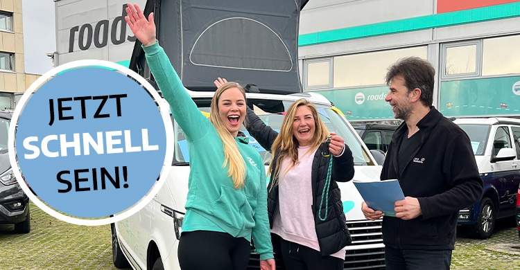 happy women with car keys in front of a campervan
