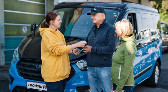 Couple picking up their campervan keys from a roadsurfer employee.