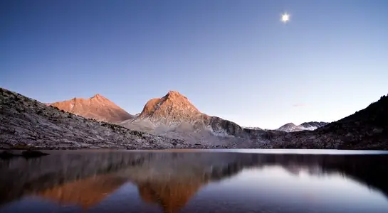 Still alpine lake reflecting Sierra Nevada peaks at dusk in Kings Canyon National Park