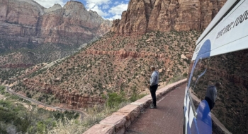 Man Looking Out Over A Canyon Next To A Parked Camper Van