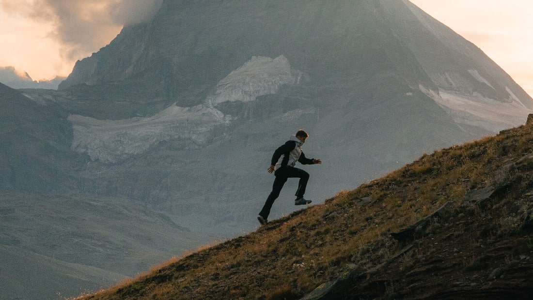 man walking up a steep mountain