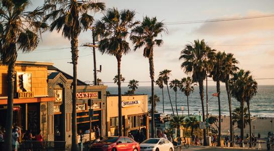 Palm trees and beachside restaurants at sunset near Manhattan Beach in Los Angeles