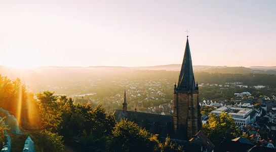 Overview of the city of Marburg with a church infront at sunset