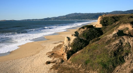 Dramatic coastal cliffs and sandy beach near Mavericks in Half Moon Bay
