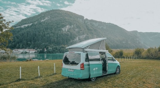 mercedes marco polo campervan next to a lake in the mountains