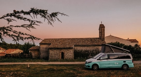 Turquoise Mercedes Vito at sunset in front of a finca