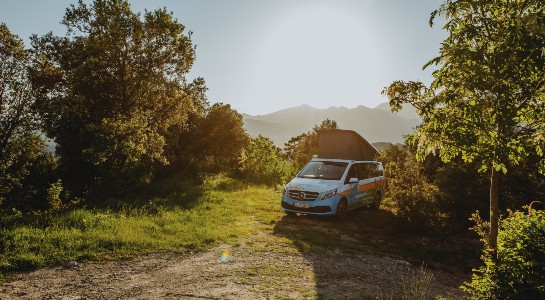 Coloured Mercedes Vito camper on a pitch in the mountains
