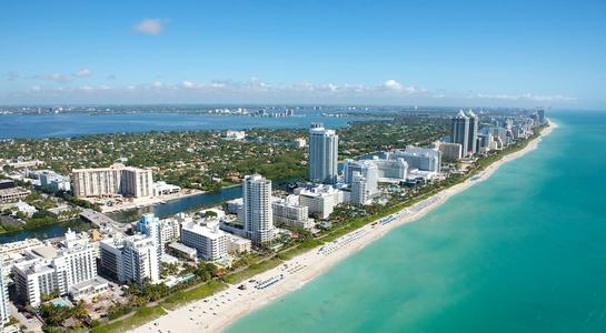 Aerial view of Miami Beach with turquoise waters and high-rise buildings, marking the final stop on an East Coast RV road trip.