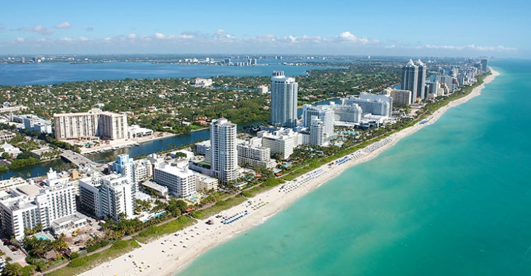 Bird view over the Miami skyline showing the skyscrapers but also the beach and Atlantic Ocean.