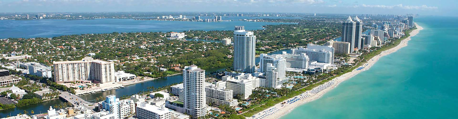 Bird view over the Miami skyline showing the skyscrapers but also the beach and Atlantic Ocean.