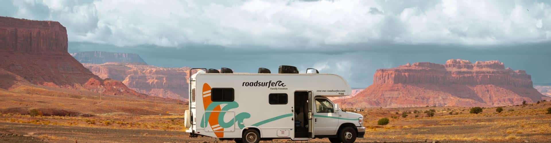 Roadsurfer RV parked in the red rock desert near Moab with dramatic mesas on a Colorado to California road trip