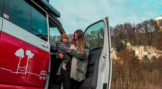 mother-and-baby-in-the-door-of-a-red-camper-van