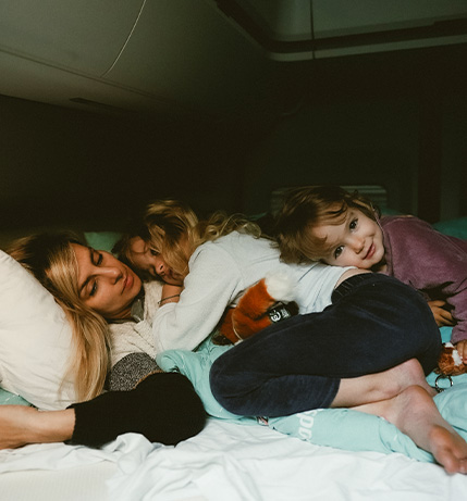 Mother and her two girls cuddling in the back of a campervan