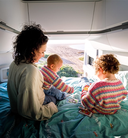 Mother with two kids playing cards in back of campervan
