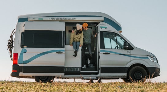 Couple sits in a motorhome parked in the meadow