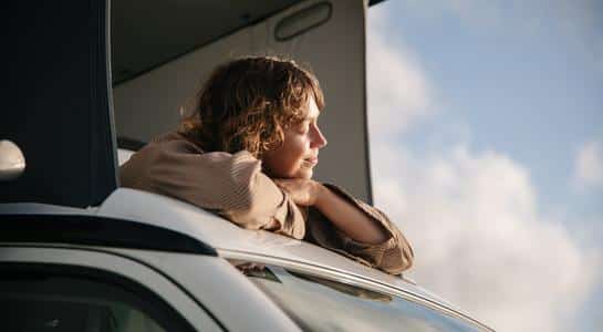 Person enjoying the view through the sunroof during a one-way RV rental trip