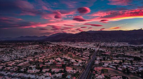 Desert sunset over Palm Springs with mountains and city lights, the perfect close to a weekend getaway from LA