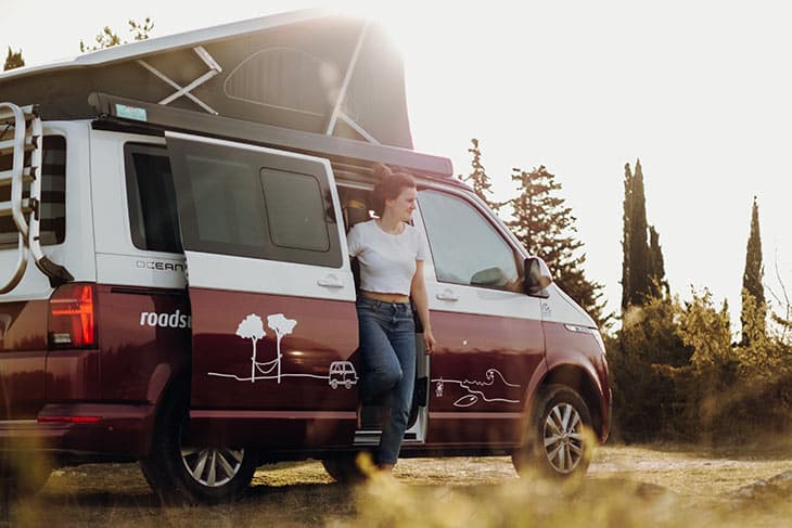 women with her roadsurfer campervan in the forest