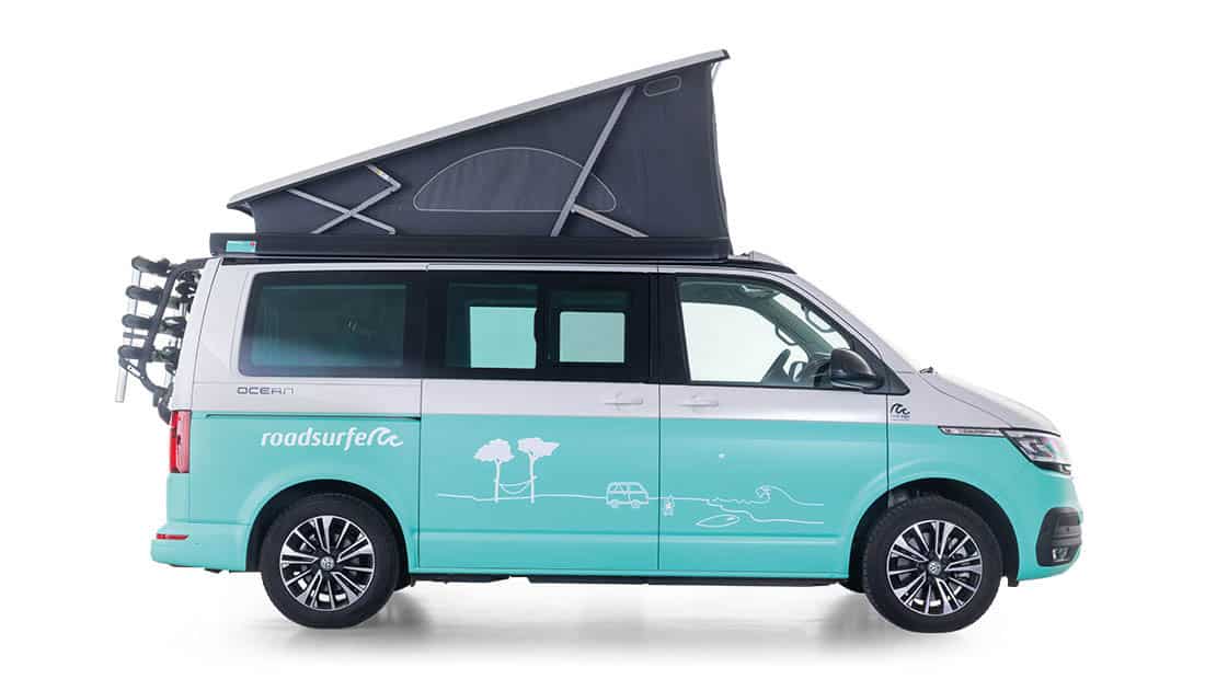 vw california ocean as roadsurfer campervan surfer suite in blue with pop up roof from the profile view