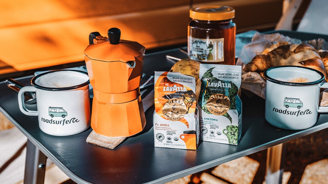 roadsurfer cups and brandpartner lavazza coffe on a camping table