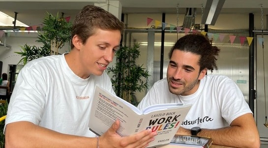 Zwei roadsurfer Mitarbeiter lesen zusammen in einem Buch