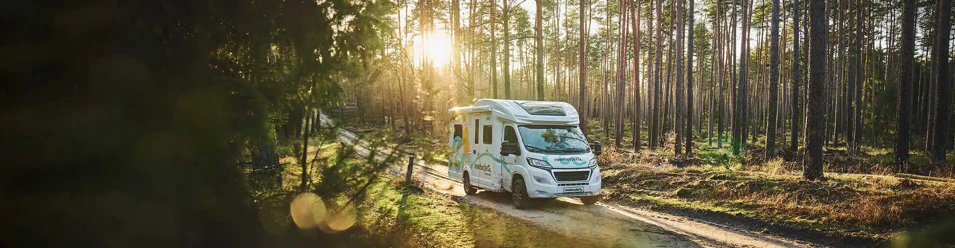 roadsurfer RV in a sunny forest