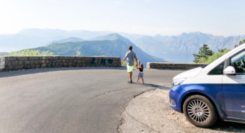 father and child on a street in slovenia, blue van in the front