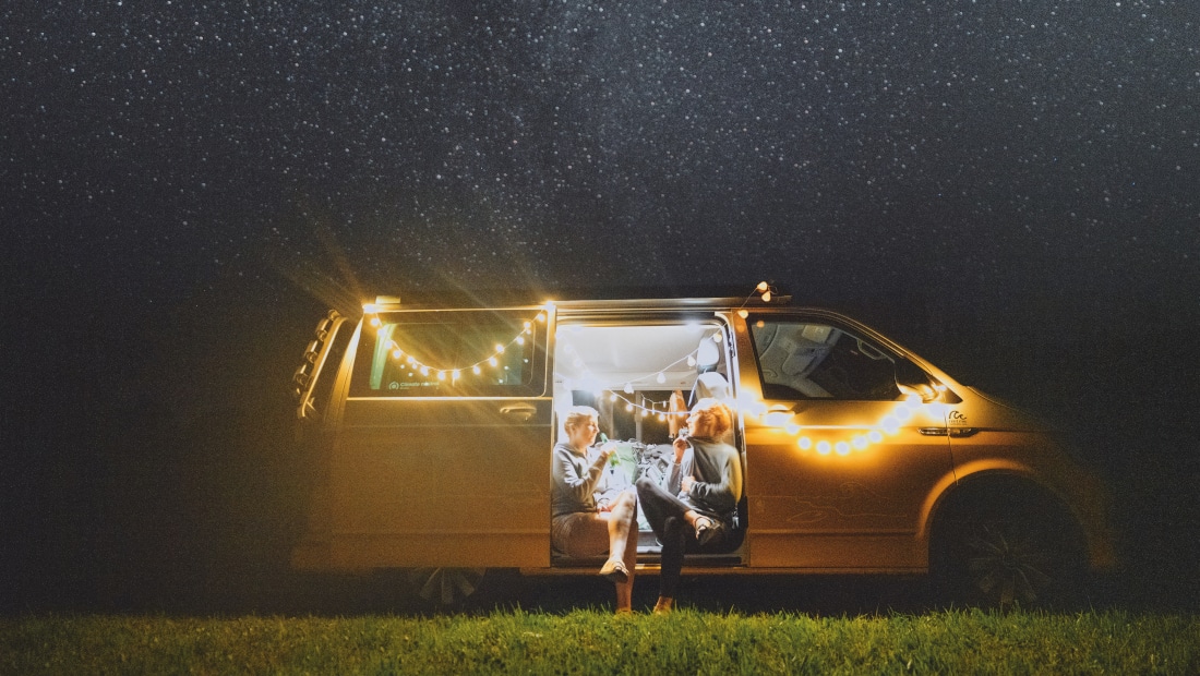 lighted van standing on a field by night