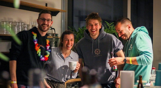 roadsurfer Team Bild mit vier Mitarbeitern bei einer Kaffeepause, lächelnde Gesichter