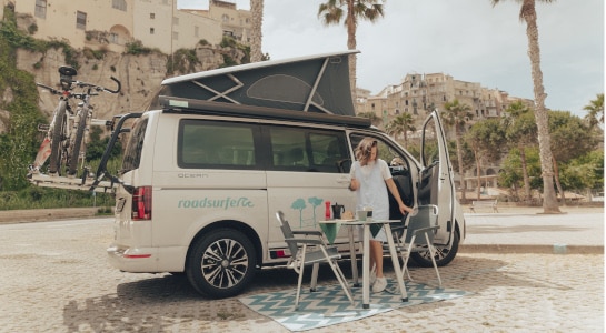 white VW campervan with open roof in front of an italian castle