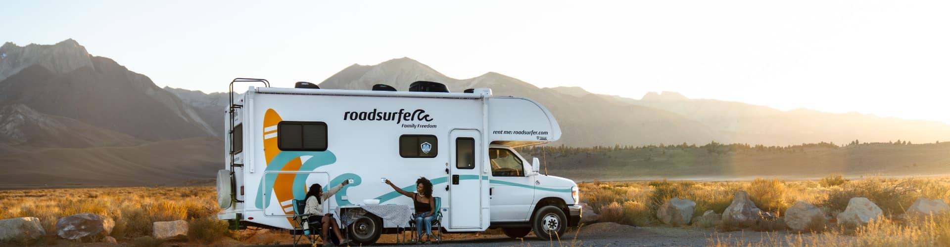 Family enjoying a roadsurfer RV at sunset in the mountains, a relaxed moment that fits an RV insurance road trip guide