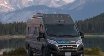 RV parked beside a mountain lake during a road trip, illustrating the experience of renting a camper for outdoor travel