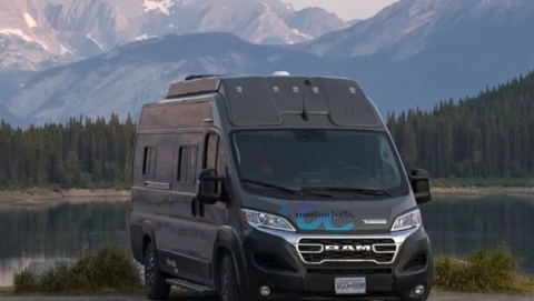 RV parked beside a mountain lake during a road trip, illustrating the experience of renting a camper for outdoor travel